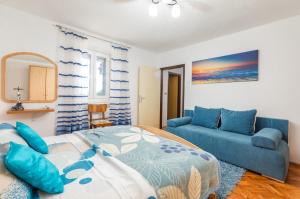 a bedroom with a bed and a blue couch at Holiday home Dioniza in Gajana +38 photos
