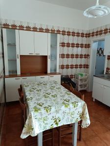 une cuisine avec une table recouverte d'une nappe dans l'établissement Casa Nettuno, à Lido Conchiglia