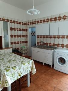une cuisine avec une table et une machine à laver dans l'établissement Casa Nettuno, à Lido Conchiglia