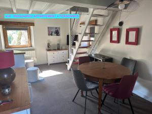 a room with a table and chairs and a staircase at MAISON DES VIGNES- TROQUAÏROU et BECCA MOTTA in Brides-les-Bains