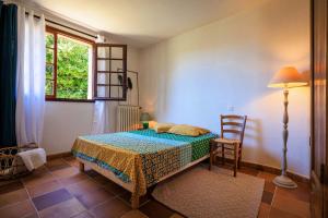 a bedroom with a bed and a lamp and a window at Maison Canorgues in Tourrettes-sur-Loup