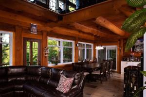 salon ze skórzaną kanapą i stołem w obiekcie Spa & Outdoor Pool - Montagnard des Pays-d'en-Haut w mieście Sainte-Adèle +30 zdjęć