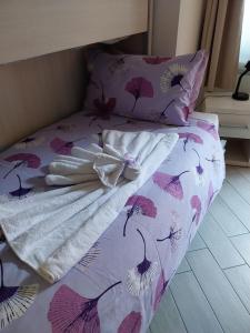 a bed with a pink and white comforter and pillows at BelSorrisoVarese - Family Room - Private Parking - Reservation Required in Varese +7 photos