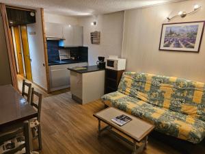 a living room with a couch and a kitchen at Piolit andCo - Studio vue montagne in Ancelle