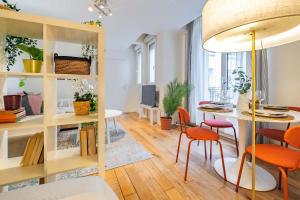 una sala de estar con una mesa y sillas en 4 Guest Flat Central in Montorgueil, en París