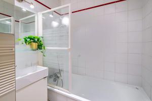 Un baño blanco con bañera y lavabo. en 4 Guest Flat Central in Montorgueil, en París 11 fotos más