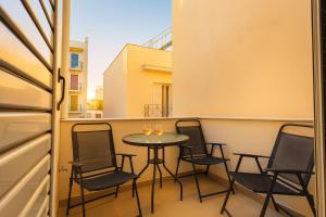 een balkon met een tafel en stoelen erop bij Upscale Modern Escape in the Historic Center in Kalamata +22 foto's