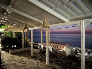 a covered patio with a view of the ocean at Emmy Rooms in Armenistis