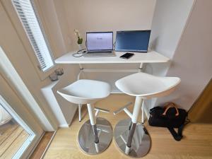 escritorio blanco con ordenador portátil y silla en Viherpihan helmi, en Espoo