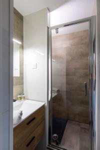 ein Badezimmer mit Dusche und weißem Waschbecken in der Unterkunft Le Prorel appartement au pied du télécabine in Briançon