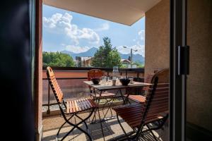 eine Terrasse mit Tisch und Stühlen auf einem Balkon in der Unterkunft Le Prorel appartement au pied du télécabine in Briançon