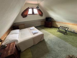 a bedroom with a large bed and a window at Hotel Pałacyk Konin in Konin