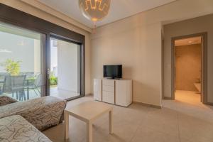 a living room with a couch and a tv at SithoniaRS Emerald Luxury Apartment in Nikiti +42 photos