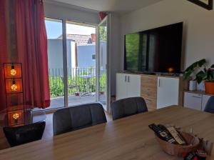 a dining room with a table and a large screen television at TOP Ferienwohnung Rosanna - Adults only in Graz
