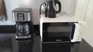 a microwave and a coffee maker on a counter at Embruns 2 in Le Moule