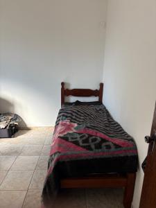 a bed with a blanket on it in a room at Vovó Rubens Casa familiar in Piauí