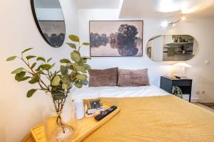 a bedroom with a bed and a table with a vase at Studio in heart of Paris in Paris