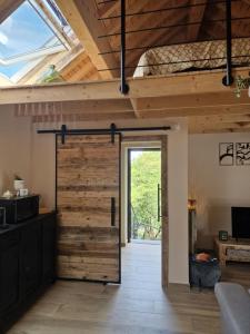 a sliding barn door in a room with wooden ceilings at La Grange in Wasseiges