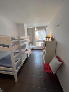a room with two bunk beds and a desk and a chair at Tahití9H in El Campello