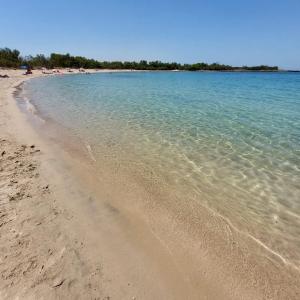 einen Sandstrand mit Menschen im Wasser in der Unterkunft Appartamento Frisa del Salento Room in centro storico Mesagne in Mesagne