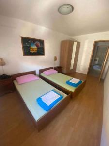 two beds in a small room with wooden floors at Holiday home in Novi Vinodolski 15408 in Novi Vinodolski