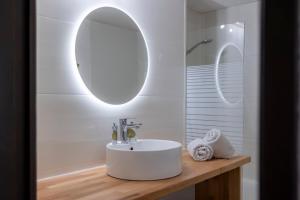 a bathroom with a white sink and a mirror at La Ruinée Appartement chaleureux à proximité des pistes et commodités in Briançon +17 photos
