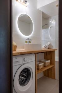 a bathroom with a washing machine and a mirror at La Ruinée Appartement chaleureux à proximité des pistes et commodités in Briançon
