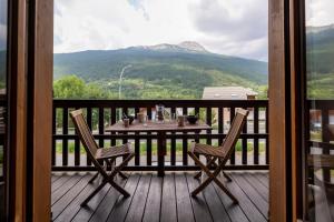a table and chairs on a balcony with a view at La Ruinée Appartement chaleureux à proximité des pistes et commodités in Briançon