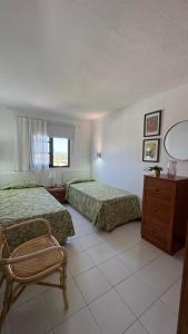 a hotel room with two beds and a chair at Golden Views Apartment in San Bartolomé +41 photos