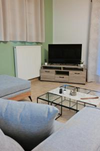 a living room with a tv and a couch at Epiphany Moudros Apartment in Moúdhros