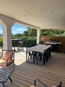 eine Terrasse mit Tisch und Stühlen auf einem Deck in der Unterkunft Maison de vacances en Camargue in Marsillargues