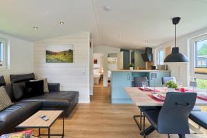 una sala de estar con un sofá y una mesa en Ostseecamp Ferienhaus "Sauerländer", en Scharbeutz