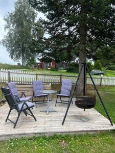 a group of chairs and a table and a tree at Enebolig til 9 gjester nær Oslo lufthavn in Eidsvoll