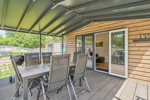 Un patio con una mesa y sillas en una terraza. en Ostseecamp Ferienhaus "Sauerländer", en Scharbeutz 24 fotos más