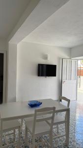 a white dining room with a white table and chairs at Perla Bianca Holiday Home, Forio in Ischia +17 photos