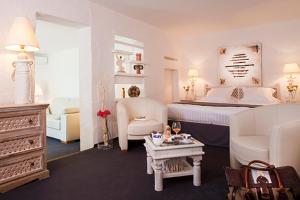 a bedroom with a bed and a living room at Mangio Fango Hotel et Spa in Saintes-Maries-de-la-Mer