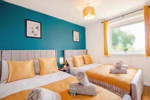 a bedroom with two beds and a blue wall at Blue Ocean Stays Retreat Free Parking 12ppl in Heeley