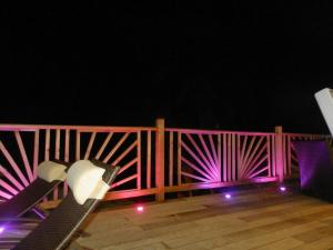a bench on a deck with a pink fence at Villa Palma avec vue mer et piscine privée location Domaine de la Pointe Batterie à Deshaies in Deshaies