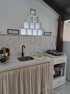 a kitchen counter with a sink and a stack of plates at Lo de lili in Ramallo