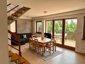 a living room with a table and chairs and a staircase at Domek Buflak in Nowy Targ