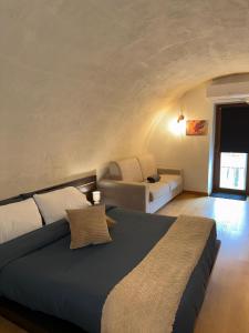 een slaapkamer met een groot bed en een bank bij Bellavita Rooms-Matera Arco 34 in Matera