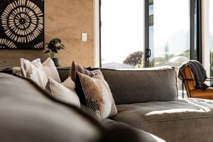 a couch with pillows on it in a living room at Embers Bay of Fires in Binalong Bay