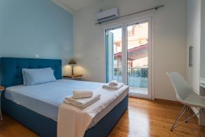 een slaapkamer met een bed en een groot raam bij Upscale Modern Escape in the Historic Center in Kalamata