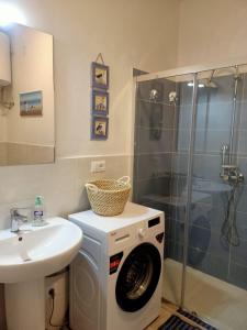 a bathroom with a washing machine and a sink at Vista Bella House in Sanremo