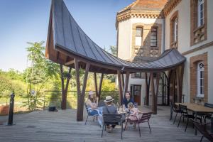 a group of people sitting in chairs under a gazebo at Hotellerie de l'Abbaye du Désert in Bellegarde