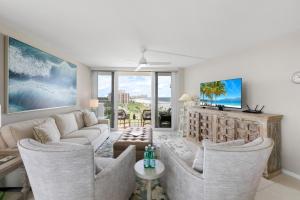 a living room with a couch and chairs at SW facing beachfront condo with sweeping ocean views in Marco Island