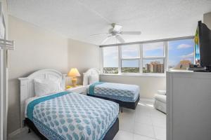 a bedroom with two beds and a window at SW facing beachfront condo with sweeping ocean views in Marco Island +22 photos