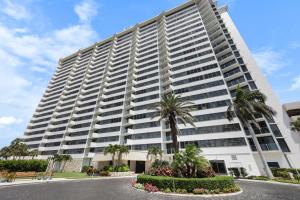 a large white building with palm trees in front of it at SW facing beachfront condo with sweeping ocean views in Marco Island