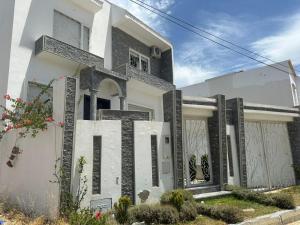 タンジェにあるLocation villa vacances sur tangerの「無限大」と書かれた看板のある白い家