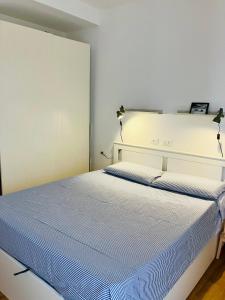 a bedroom with a white bed with blue sheets at Casa Nina in Villasanta +4 photos
